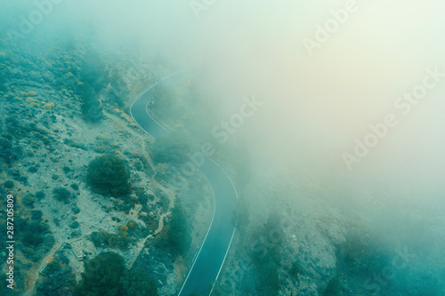 Aerial view of asphalt road with fog and maountains in autumn season. photo