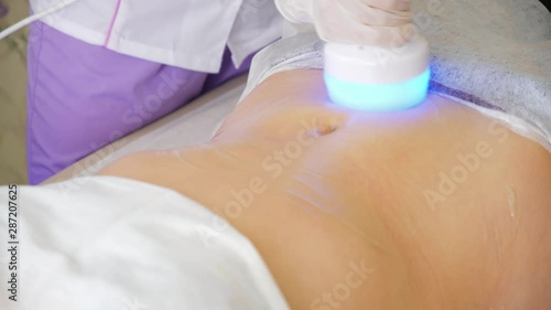 Hardware cosmetology. Body care. Spa treatment. Ultrasound cavitation body contouring treatment. Woman getting anti-cellulite and anti-fat therapy in beauty salon. photo