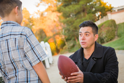Hispanic Father Holding Foo...