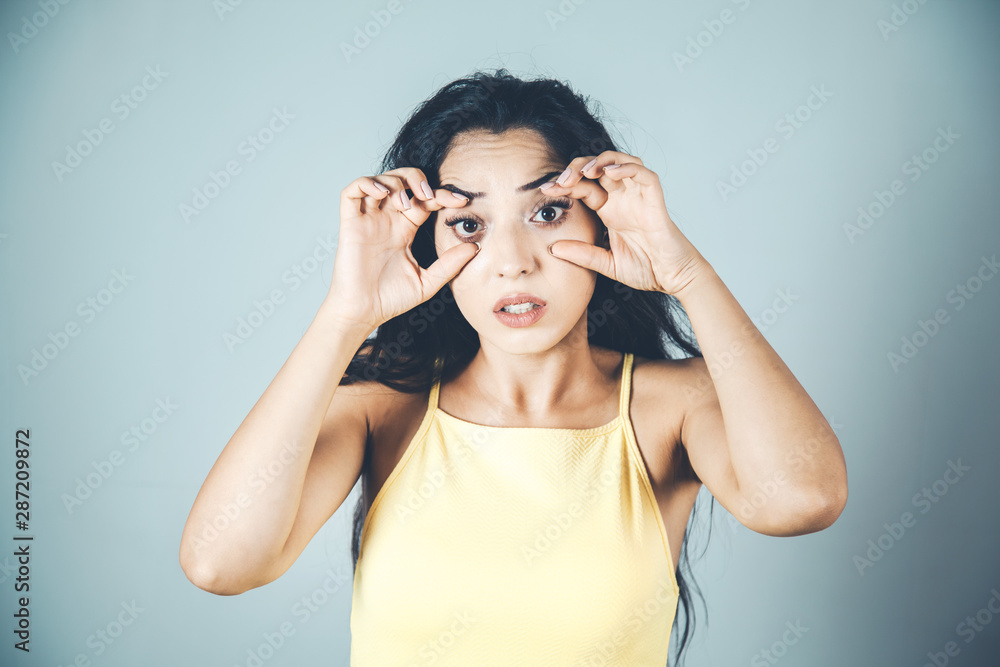 Woman trying to open eyes with fingers Woman trying to open eyes with fingers