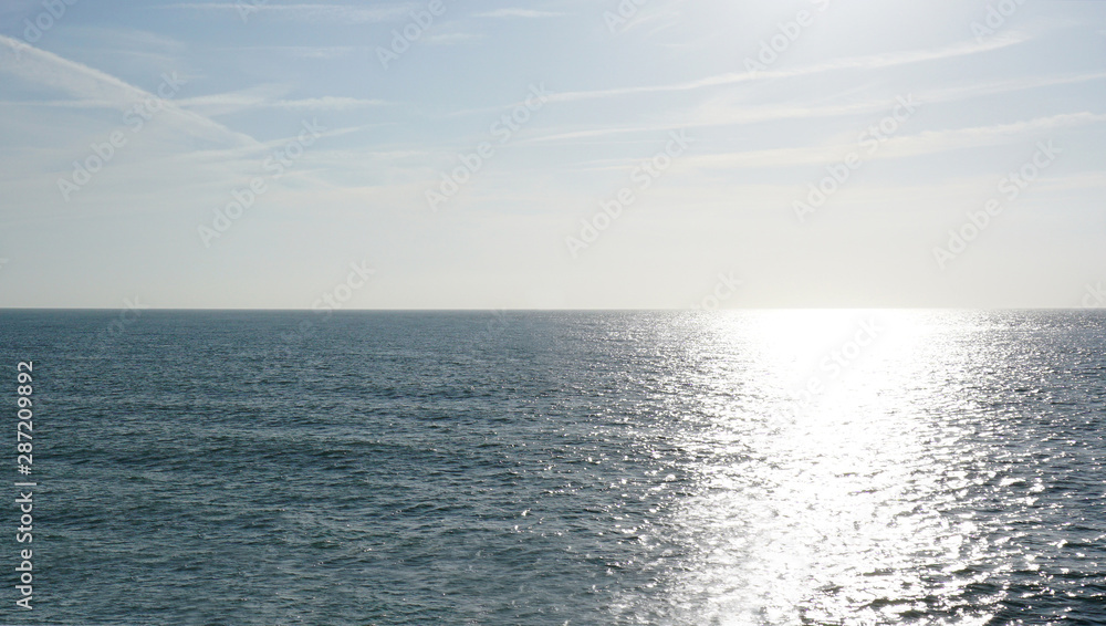 Obraz premium Empty sea to the horizon, daytime. Visible light path on the water.