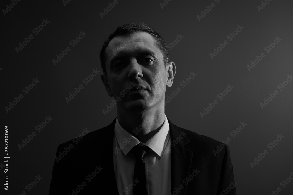 Black and white portrait of an office worker, concept of dismissal, lost a job. Businessman went bankrupt looking upset at the camera in the studio Black and white portrait of an office worker, concept of dismissal, lost a job. Businessman went bankrupt looking upset at the camera in the studio
