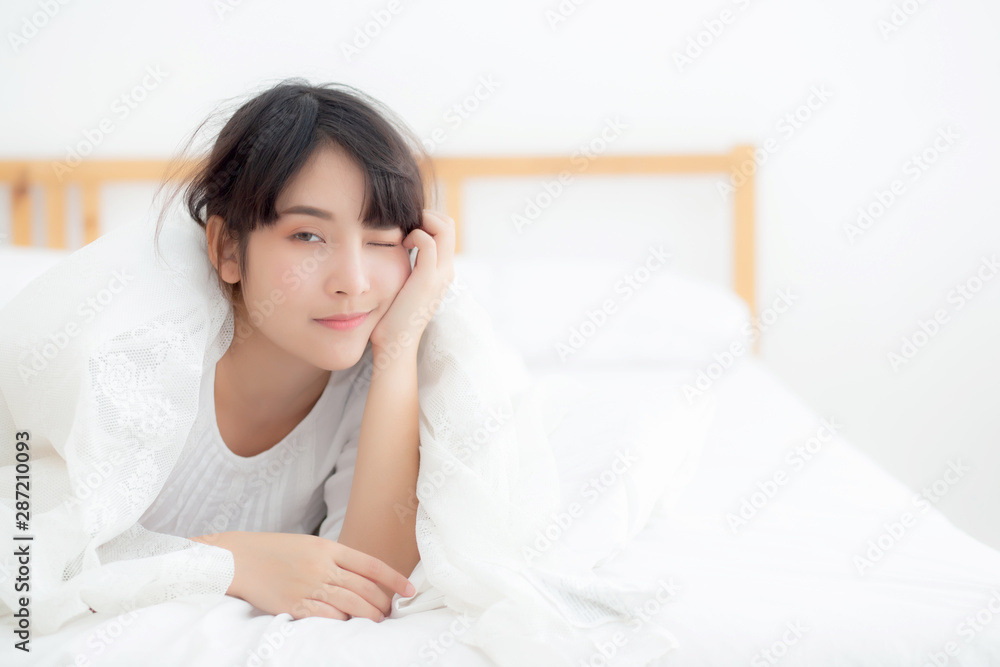 Beautiful portrait young asian woman lying and smile while wake up with sunrise at morning, girl with happy annd fun in the bedroom, lifestyle and relax concept. Beautiful portrait young asian woman lying and smile while wake up with sunrise at morning, girl with happy annd fun in the bedroom, lifestyle and relax concept.