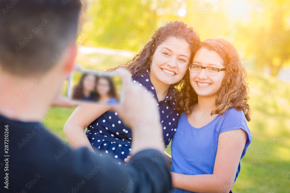 Hispanic Father Taking Picture of Mother and Daughter with Cell Phone Hispanic Father Taking Picture of Mother and Daughter with Cell Phone