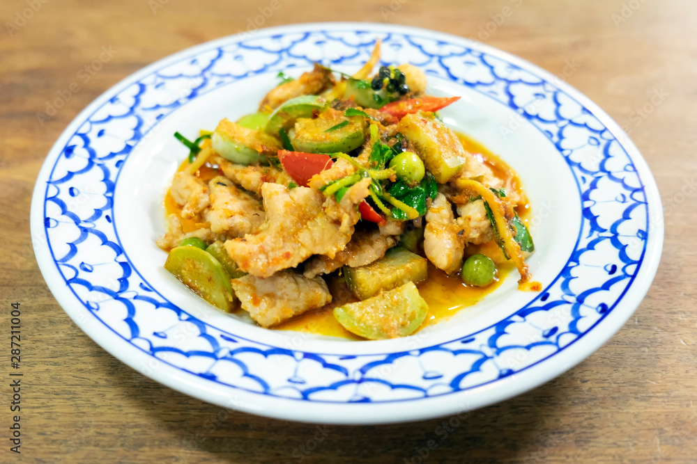 Stir-fried spicy red curry chili with pork in vintage dish. Thai local food delicious recipe.
