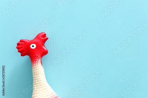 funny background of rubber chicken toy on wooden blue pastel table