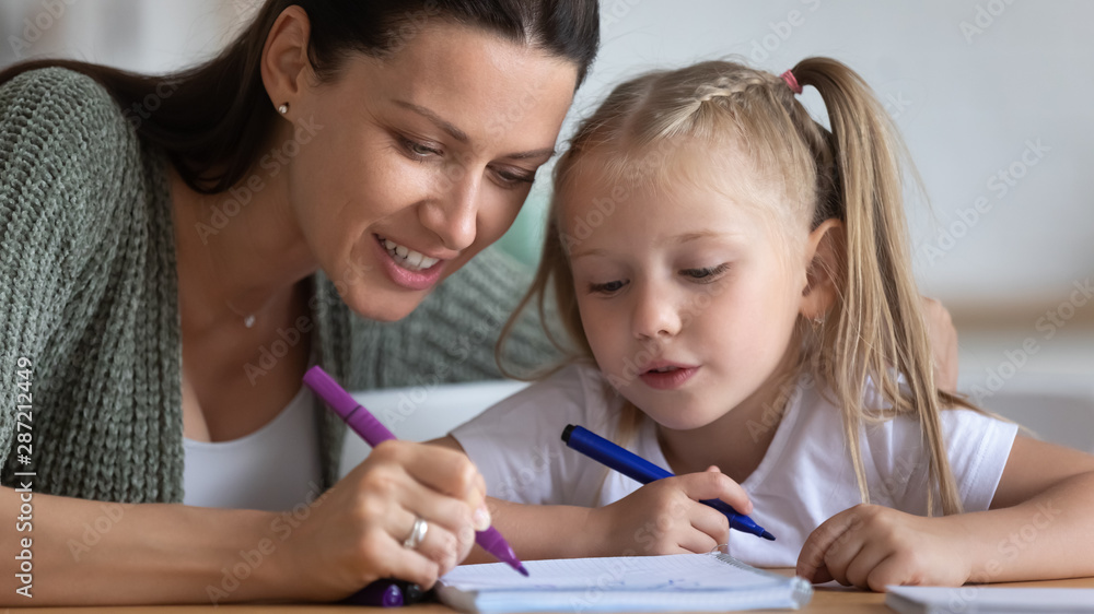 Painstaking daughter and mother draw together with felt-tip pens Painstaking daughter and mother draw together with felt-tip pens
