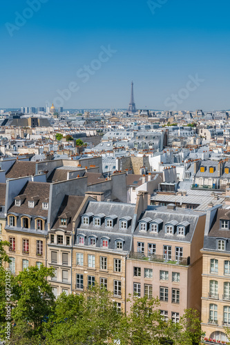 Fototapeta Naklejka Na Ścianę i Meble -  Paris, typical buildings and roofs in the Marais, aerial view from the Pompidou Center, with the Eiffel Tower in background 