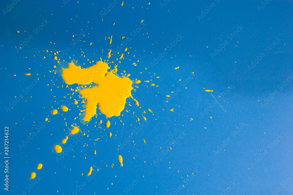 A BLOB of yellow paint on a blue background A BLOB of yellow paint on a blue background