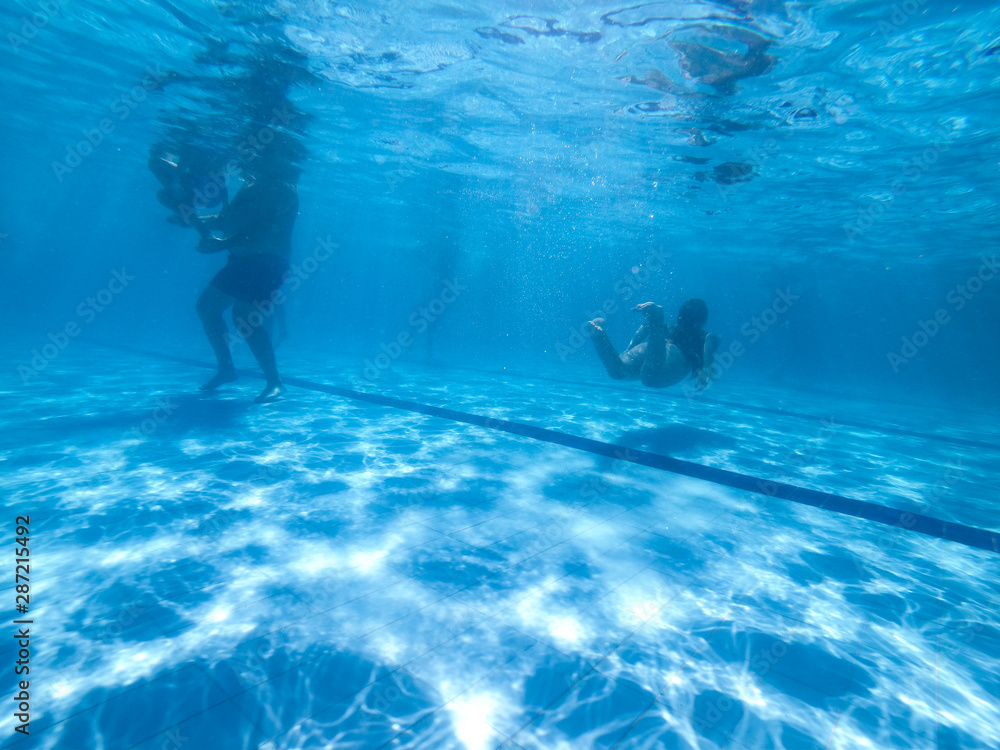 Underwater view from people in a pool in a summer day