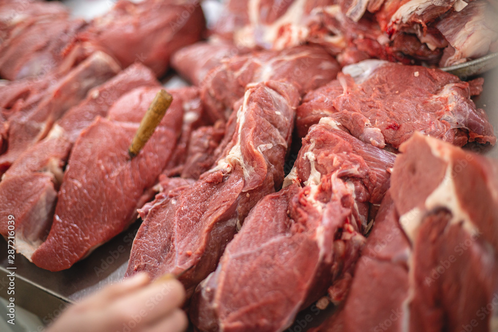 pieces of pork, veal and mutton hanging and lying side by side on the meat counter. selective focus photo from the natural home market with meat horned animals
