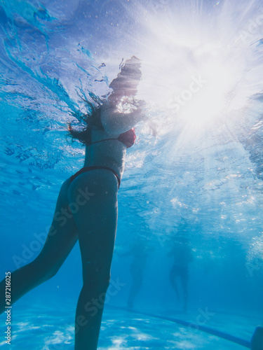 Underwater view from a girl with a red bikini in a pool