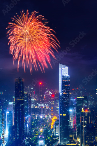 celebration firework with night cityscape of guangzhou urban skyscrapers at storm with lightning  bolts in night purple blue sky  Guangzhou  China
