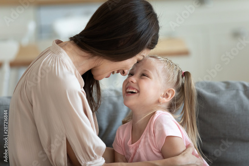 Mother daughter touch foreheads laughing enjoy time together