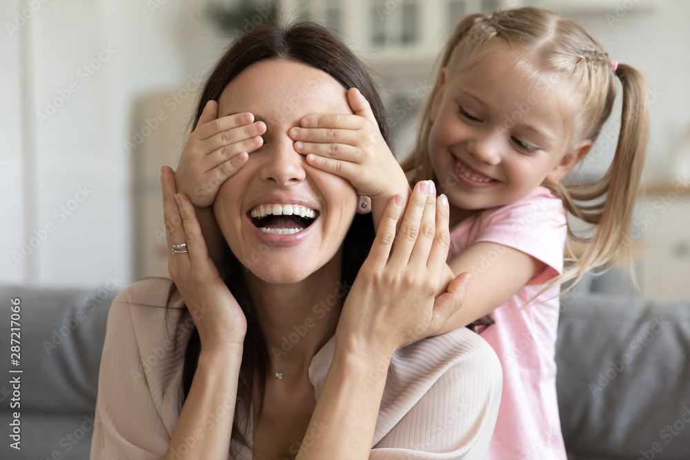 Close up image daughter closes her mother eyes with hands Close up image daughter closes her mother eyes with hands