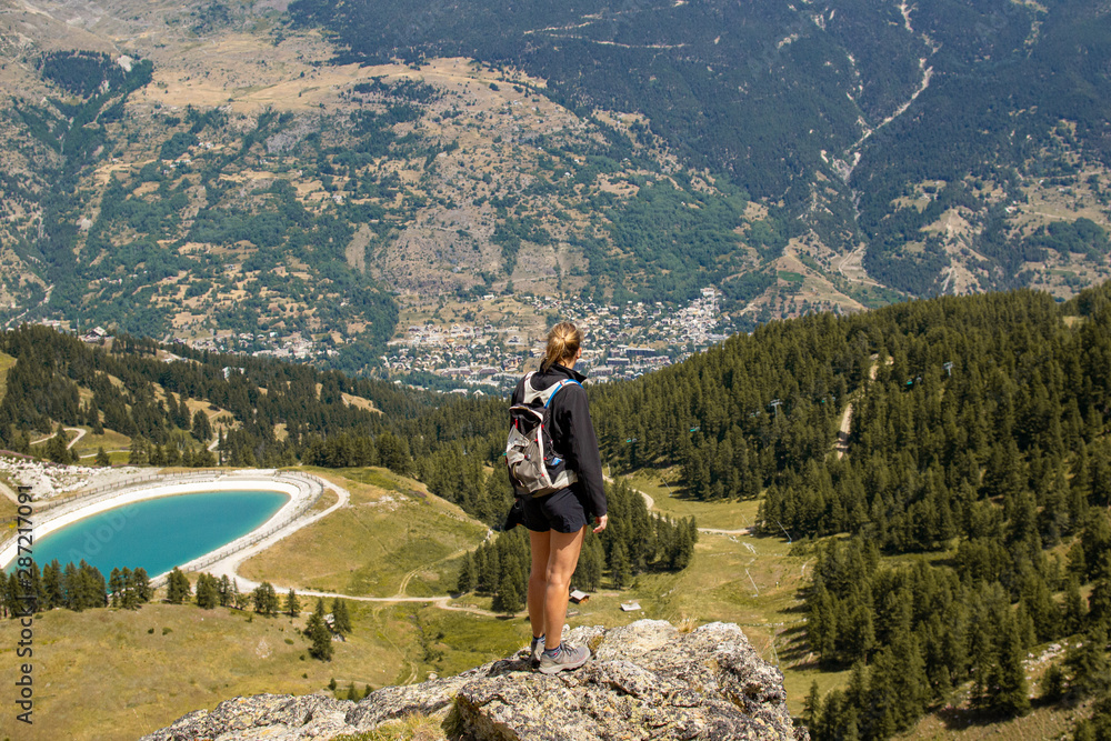 Young Girl in front of an amazing view of a valley in the French mountains