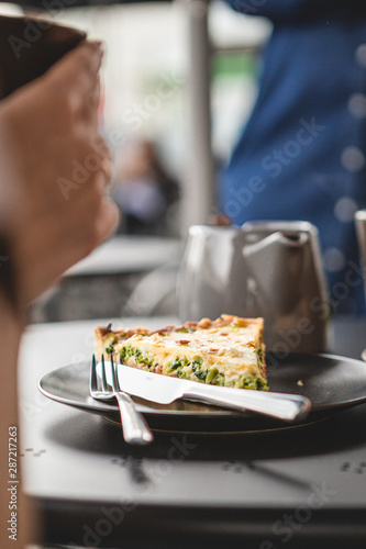 the process of eating girls in a cafe. Close up Photo of female hands holding fork and knife cutting a piece of salty pie