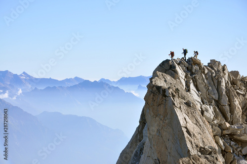 Three alpinists on rocky summit