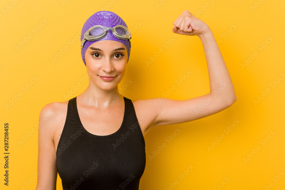 Young caucasian swimmer woman against a yellow background Young caucasian swimmer woman against a yellow background