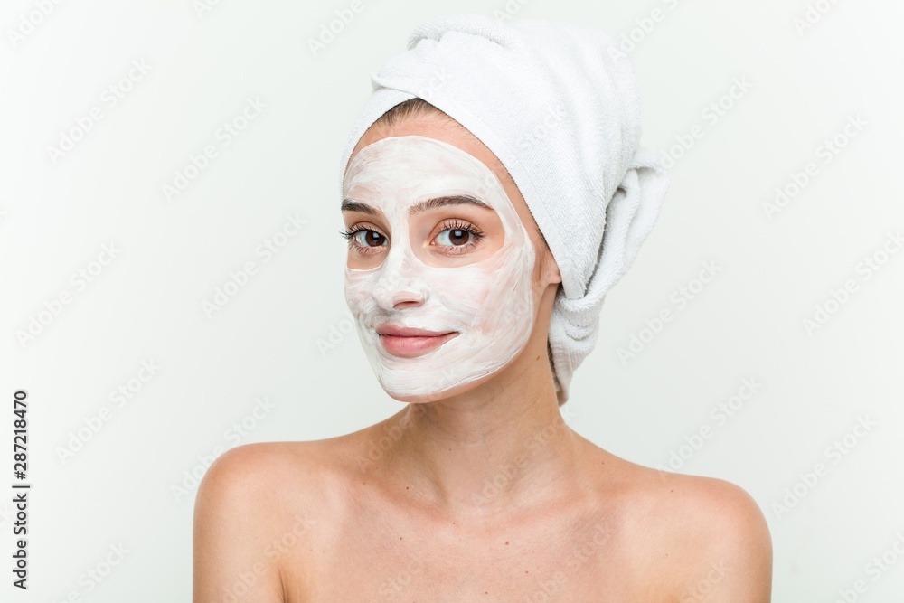 Young caucasian woman enjoying of a facial mask treatment Young caucasian woman enjoying of a facial mask treatment