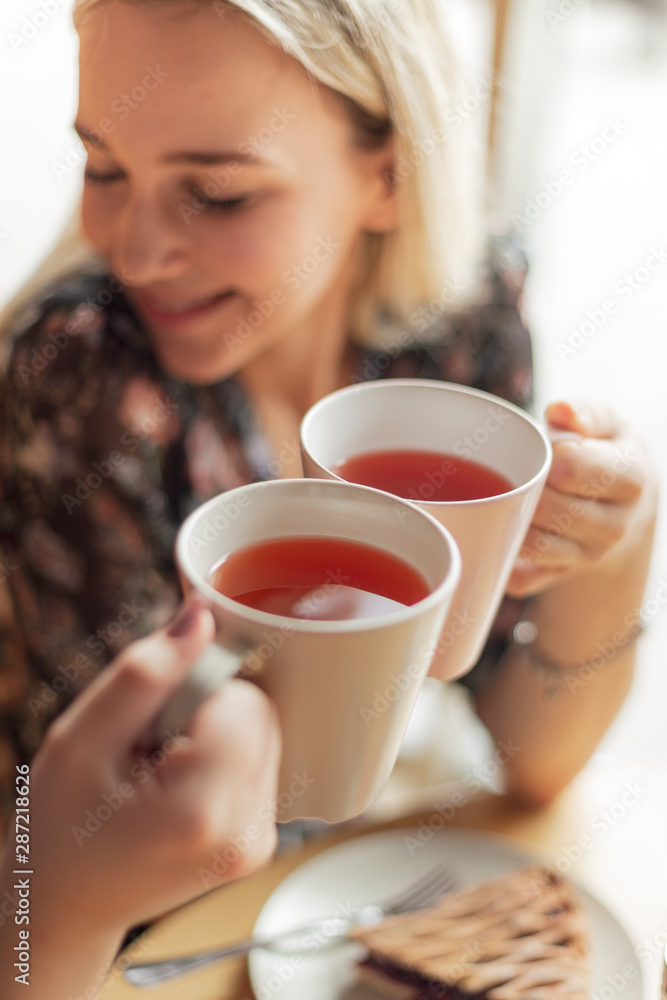 05.08.2019 Kyiv, Ukraine: two pretty women holding mugs of delicious hot tea, drinking and having fun talking 05.08.2019 Kyiv, Ukraine: two pretty women holding mugs of delicious hot tea, drinking and having fun talking