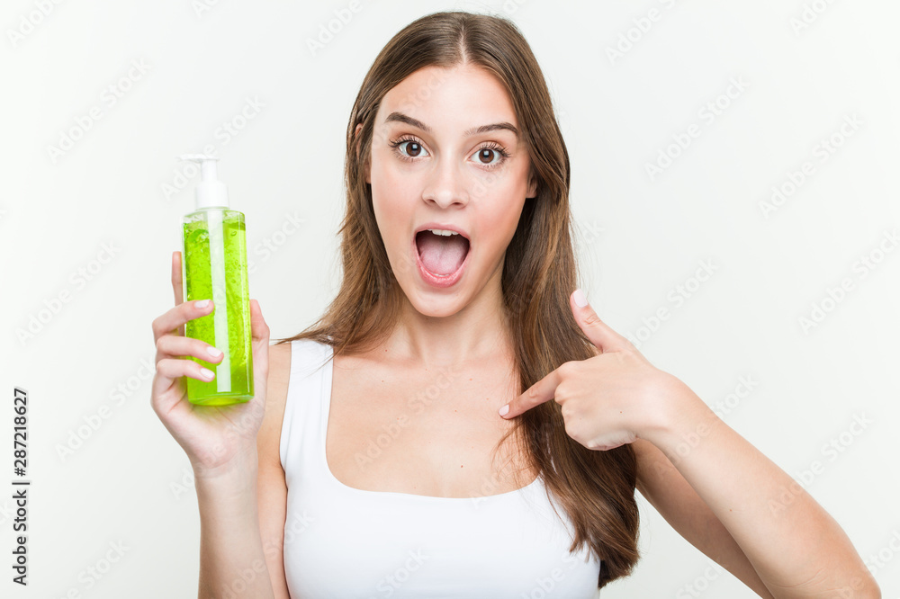 Young caucasian woman holding an aloe vera bottle surprised pointing at himself, smiling broadly. Young caucasian woman holding an aloe vera bottle surprised pointing at himself, smiling broadly.
