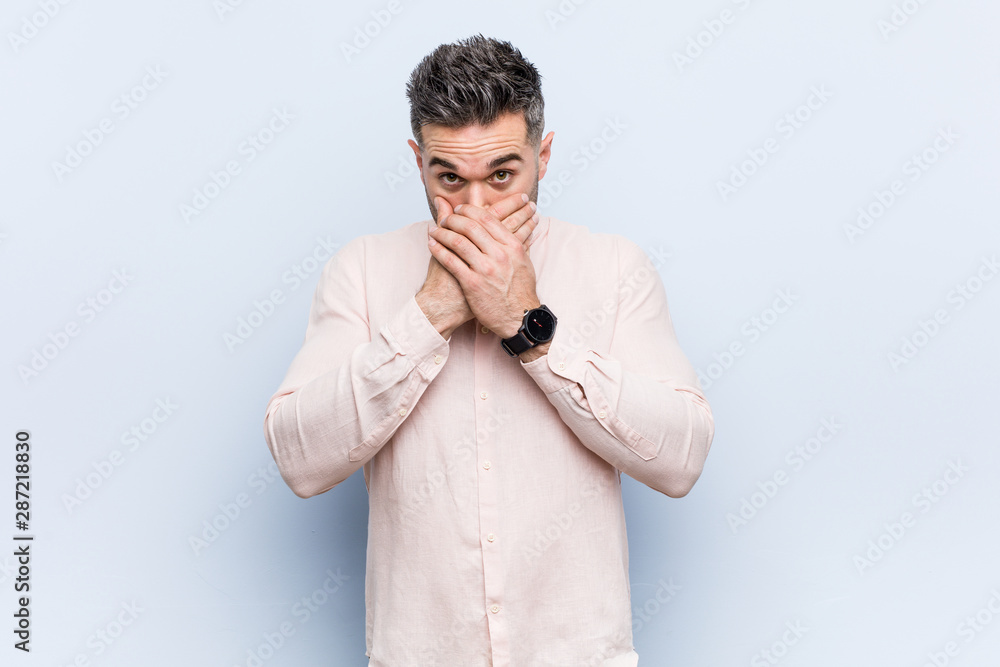 Young handsome cool man shocked covering mouth with hands. Young handsome cool man shocked covering mouth with hands.