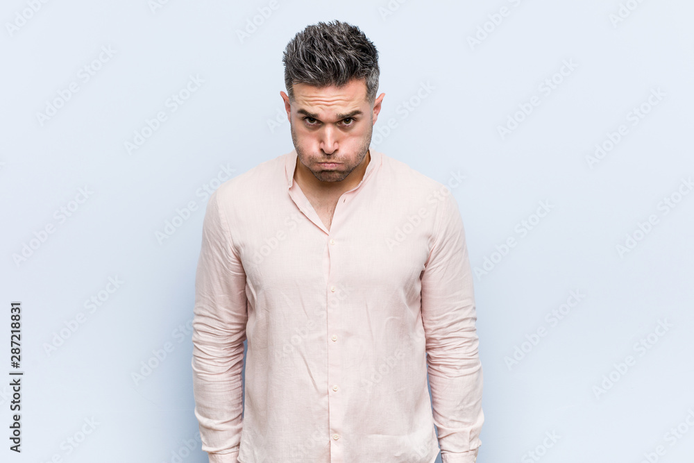 Young handsome cool man blows cheeks, has tired expression. Facial expression concept. Young handsome cool man blows cheeks, has tired expression. Facial expression concept.
