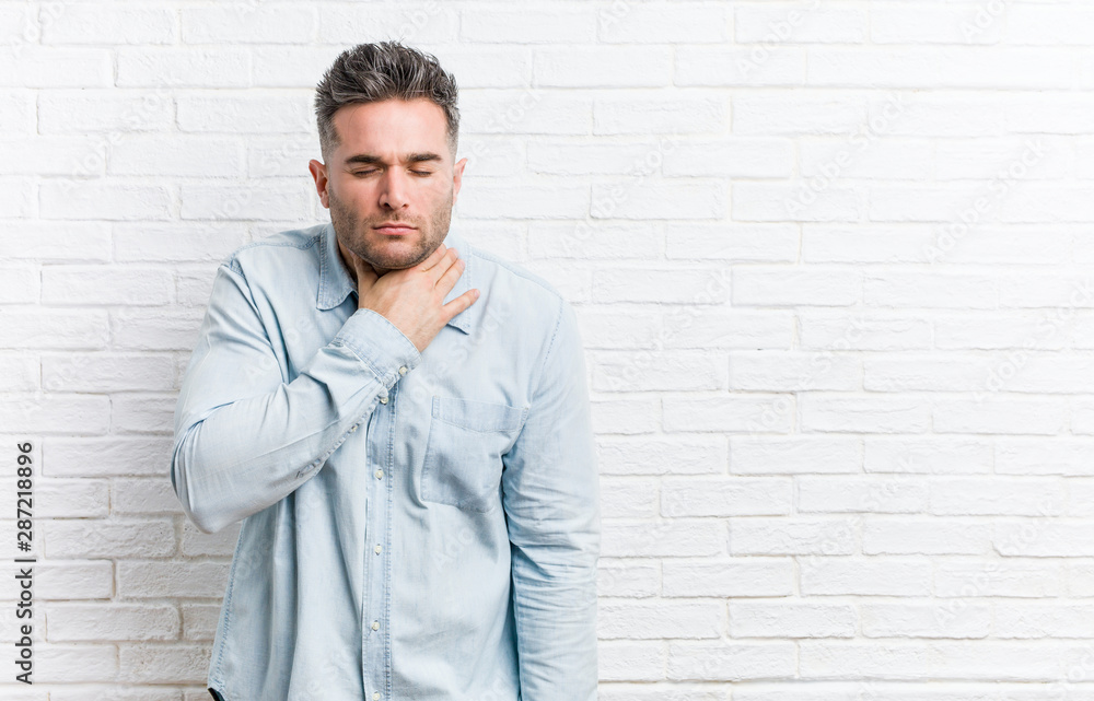 Young handsome man against a bricks wall suffers pain in throat due a virus or infection. Young handsome man against a bricks wall suffers pain in throat due a virus or infection.