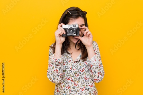 Young caucasian woman holding a vintage camera