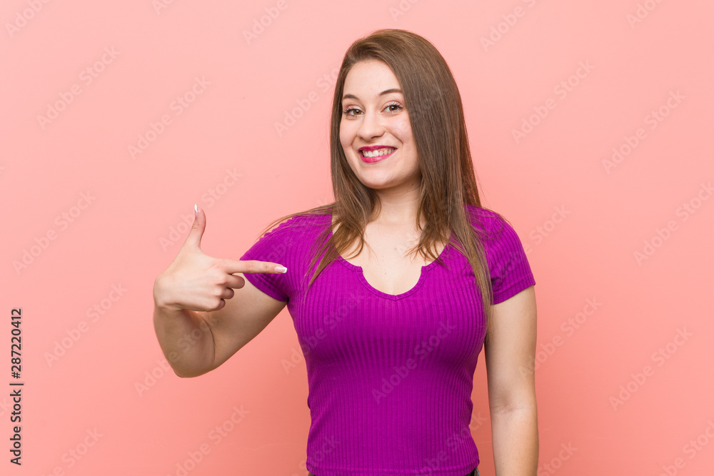 Young hispanic woman against a pink wall person pointing by hand to a shirt copy space, proud and confident Young hispanic woman against a pink wall person pointing by hand to a shirt copy space, proud and confident