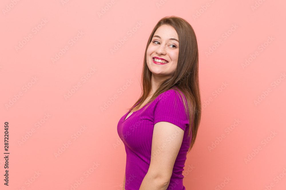 Young hispanic woman against a pink wall looks aside smiling, cheerful and pleasant. Young hispanic woman against a pink wall looks aside smiling, cheerful and pleasant.