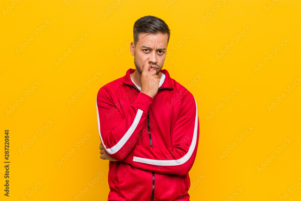 Young filipino fitness man relaxed thinking about something looking at a copy space. Young filipino fitness man relaxed thinking about something looking at a copy space.