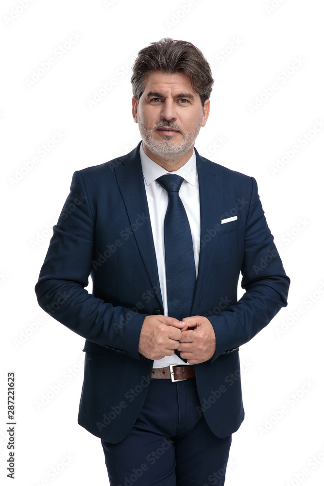 Confident businessman adjusting his jacket while walking Confident businessman adjusting his jacket while walking