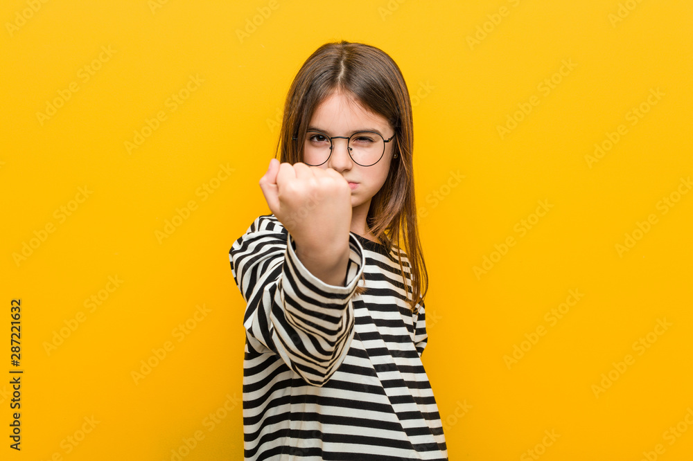 Little caucasian cute girl showing fist to camera, aggressive facial expression. Little caucasian cute girl showing fist to camera, aggressive facial expression.