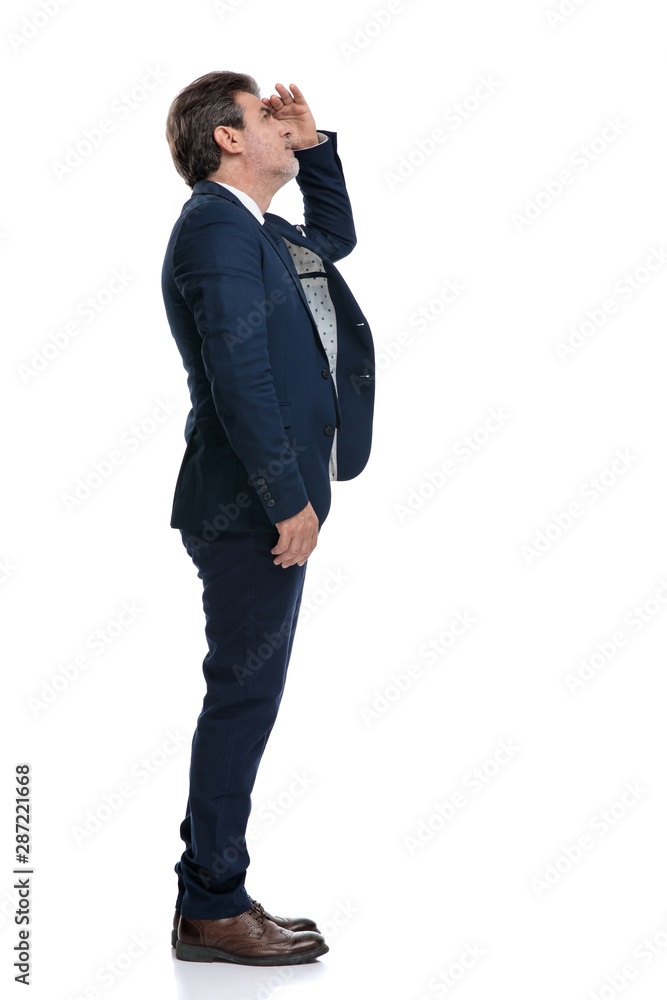 Side view of a curious businessman looking up Side view of a curious businessman looking up