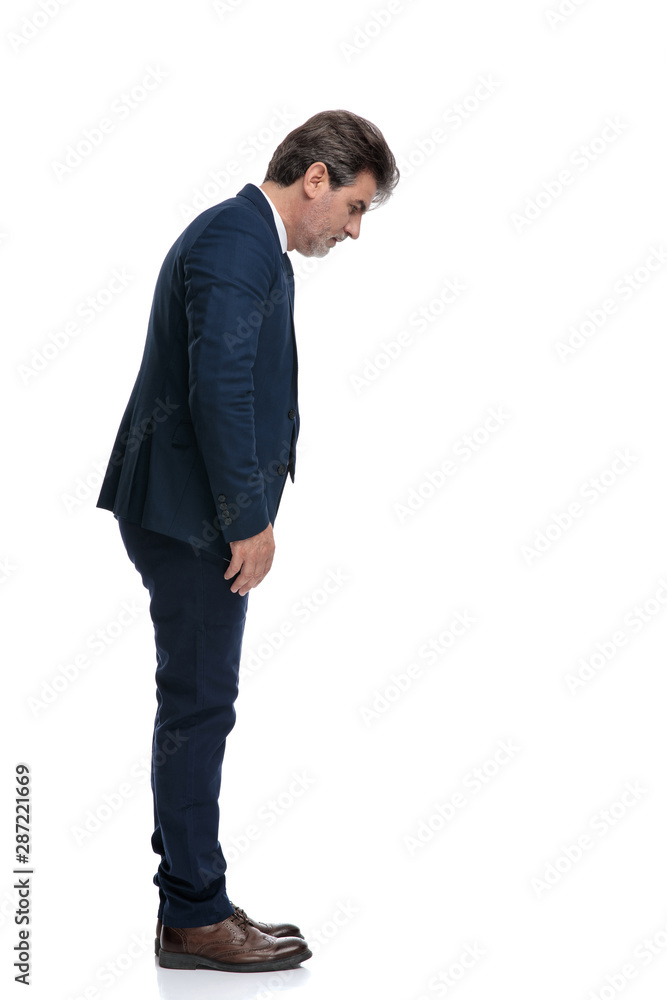 Side view of an upset businessman looking down Side view of an upset businessman looking down