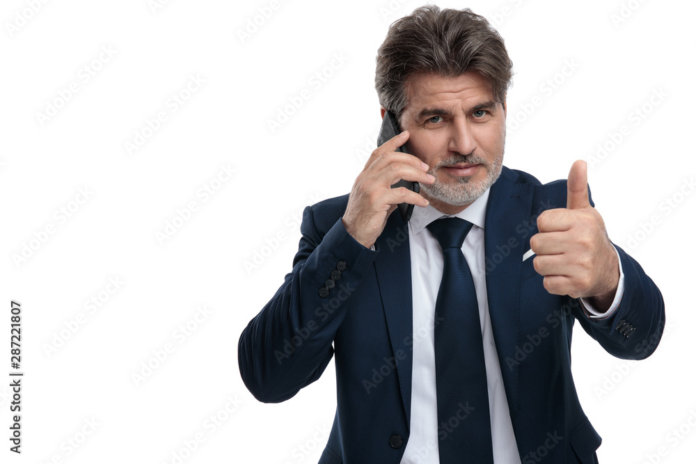 Fashion businessman gesturing ok and talking on his phone Fashion businessman gesturing ok and talking on his phone