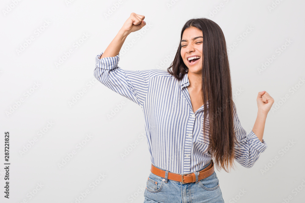 Young pretty arab woman raising fist after a victory, winner concept. Young pretty arab woman raising fist after a victory, winner concept.