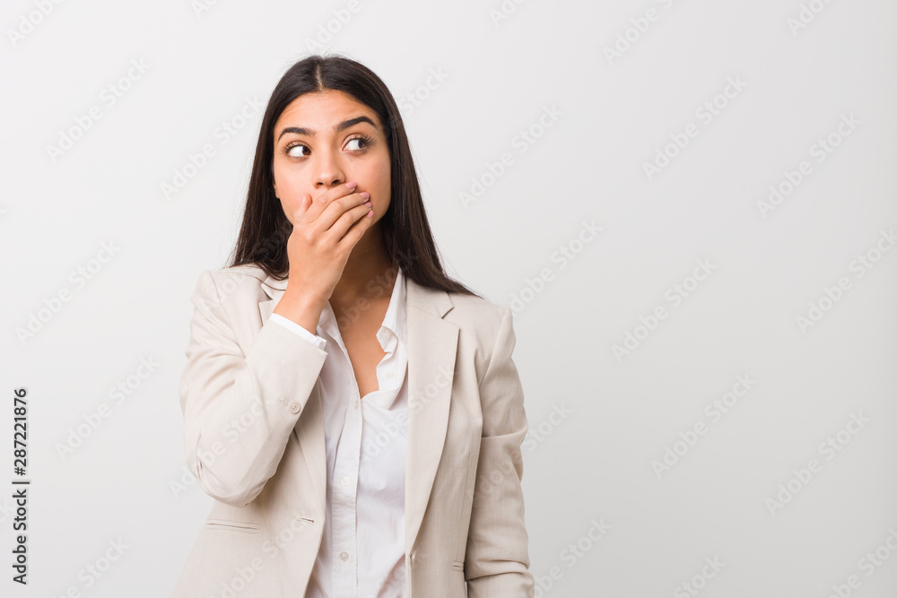 Young business arab woman isolated against a white background thoughtful looking to a copy space covering mouth with hand. Young business arab woman isolated against a white background thoughtful looking to a copy space covering mouth with hand.