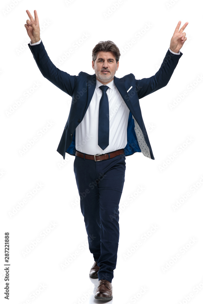 Positive businessman gesturing peace and stepping forward Positive businessman gesturing peace and stepping forward
