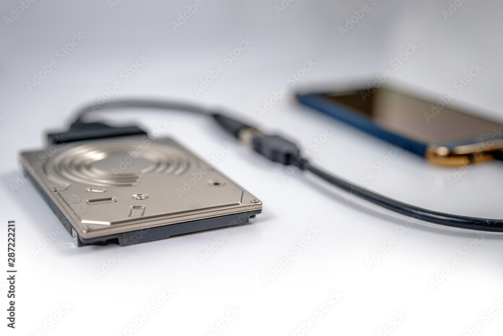 hdd 2.5 hard drive disk connected to smartphone via sata usb cable closeup overhead view hdd 2.5 hard drive disk connected to smartphone via sata usb cable closeup overhead view