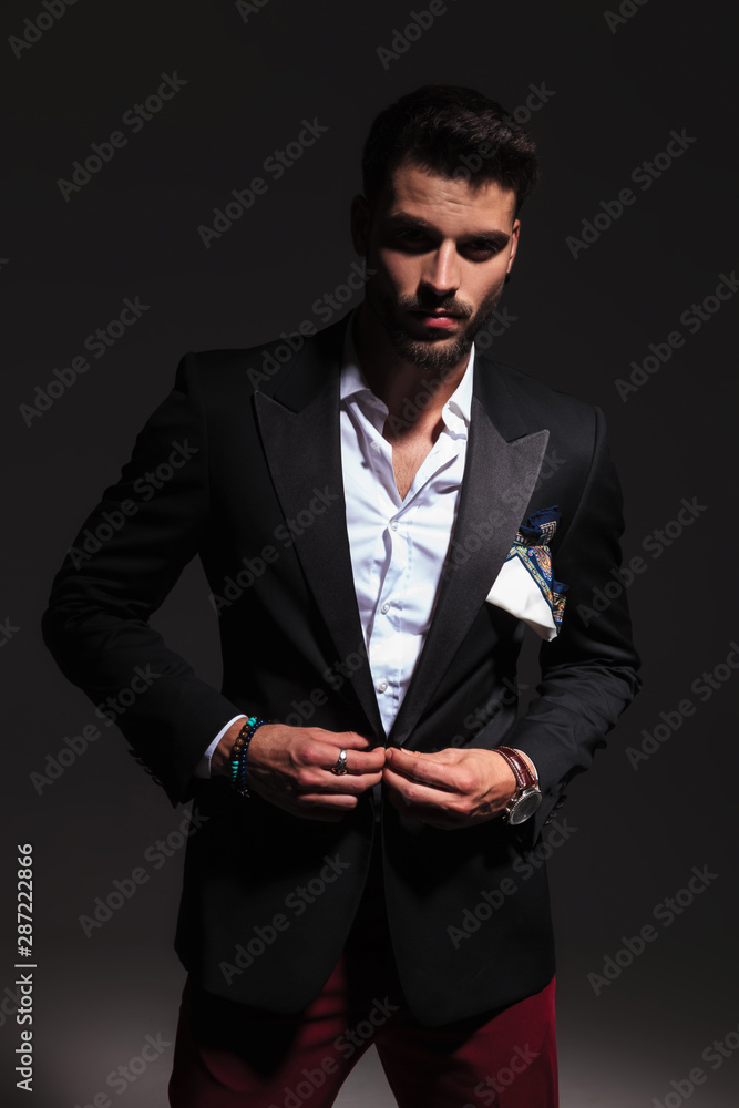 dramatic portrait of an elegant man buttoning his suit dramatic portrait of an elegant man buttoning his suit