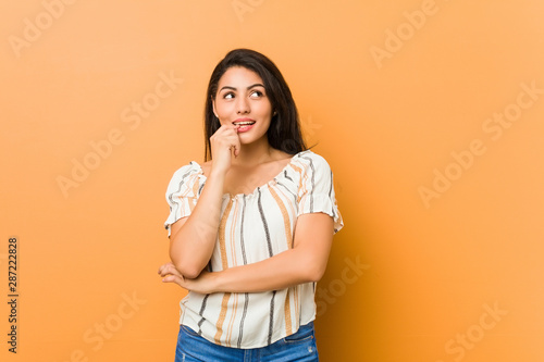 Young curvy woman relaxed thinking about something looking at a copy space.
