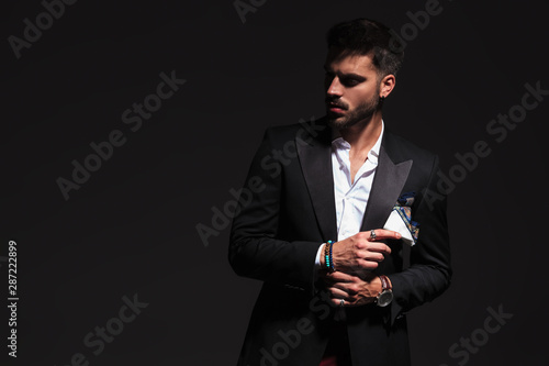 Obraz na plátně elegant man fixing his cufflinks and looks away