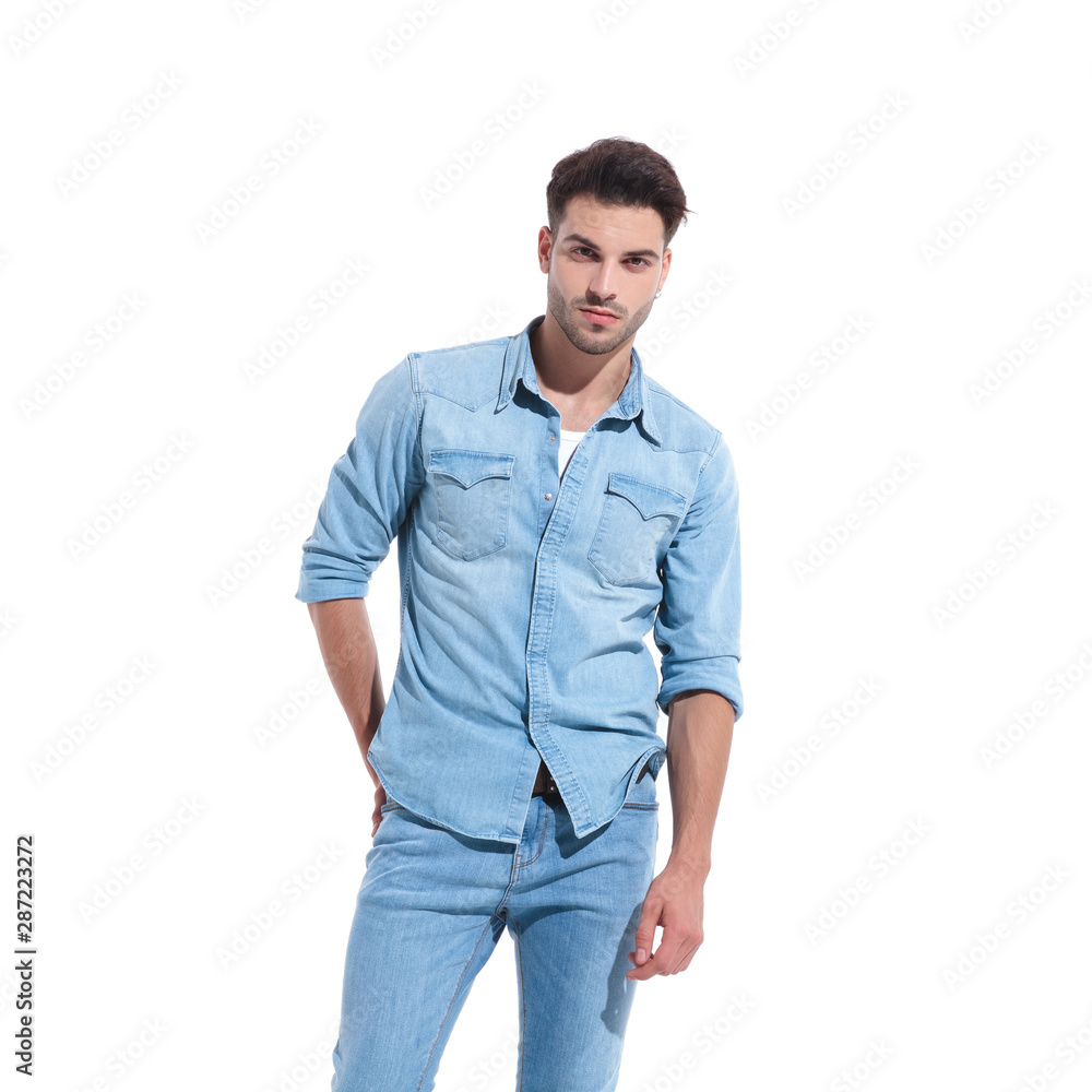 handsome young man wearing denim and holding hand on hip handsome young man wearing denim and holding hand on hip