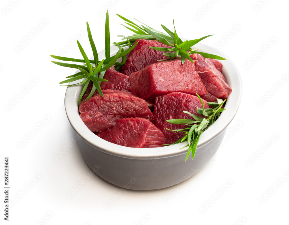 Sliced raw beef with tarragon herb isolated on white Sliced raw beef with tarragon herb isolated on white