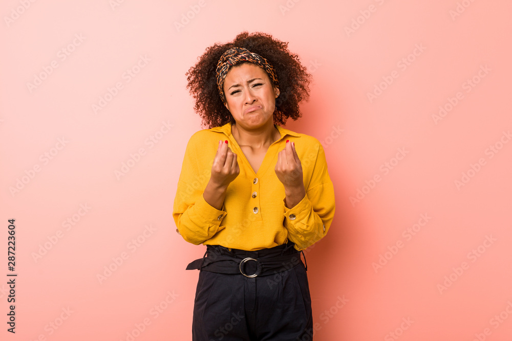 Young african american woman against a pink background showing that she has no money. Young african american woman against a pink background showing that she has no money.