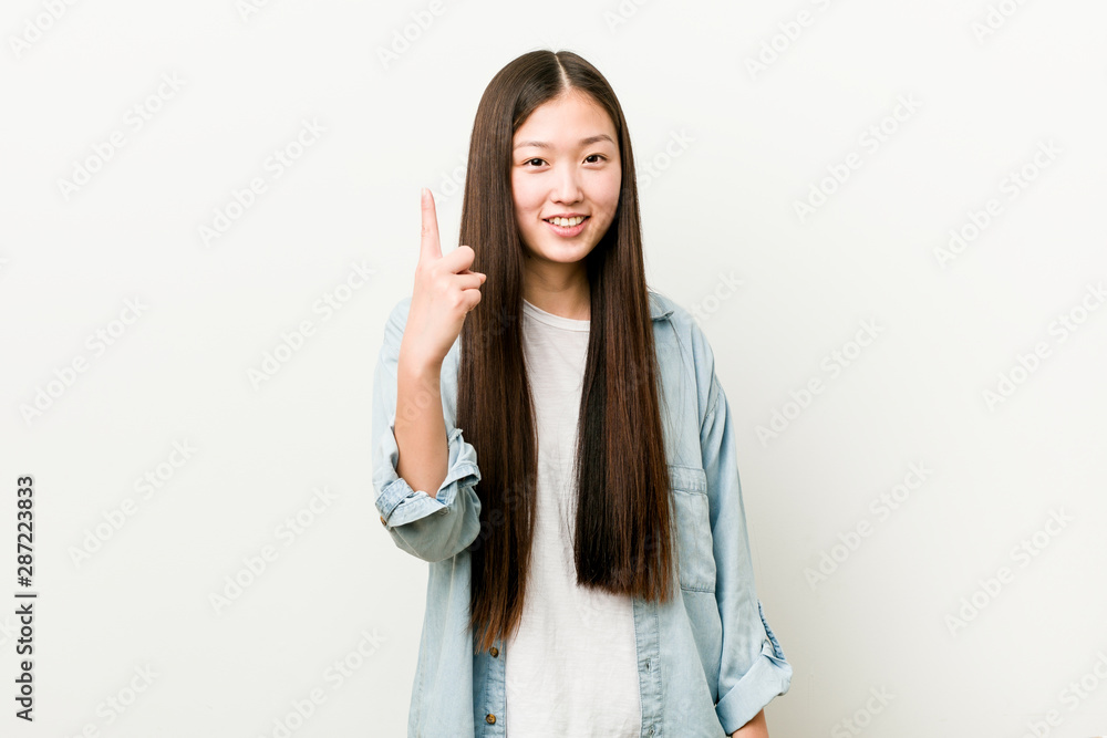 Young asian woman showing number one with finger. Young asian woman showing number one with finger.
