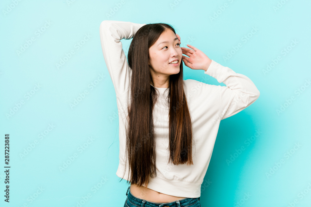 Fototapeta premium Young pretty chinese woman stretching arms, relaxed position.